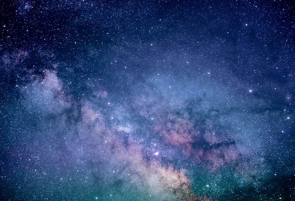Céu estrelado sobre uma paisagem escura